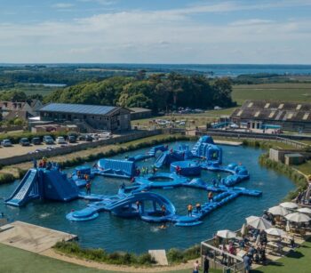 A blue inflatable aqua park on a lake. The photo is taken from the air